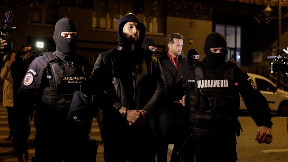 Andrew Tate and Tristan Tate are escorted by police officers outside the headquarters of the Directorate for Investigating Organized Crime and Terrorism in Bucharest (DIICOT)