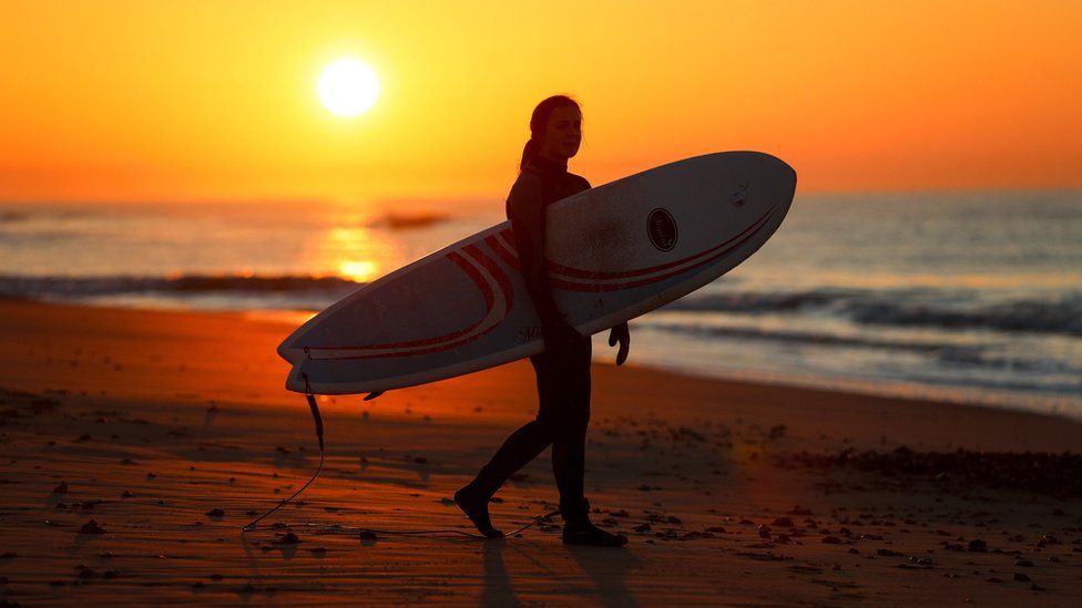 A female surfer at Boscome beach in Dorset