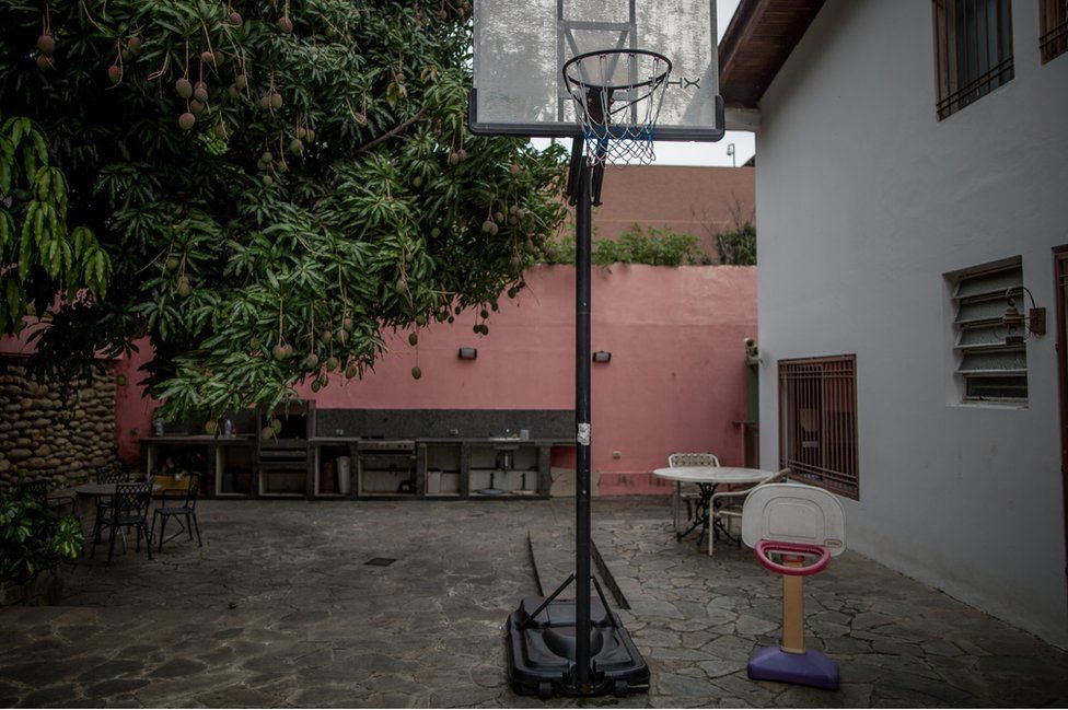 The family mango tree besides a full-size basketball hoop and a tiny one that Juan Pablo played with as a child