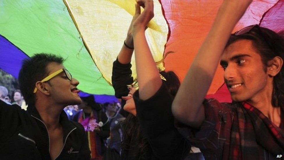 Gay rights activists display a rainbow-colored banner as they march in Delhi