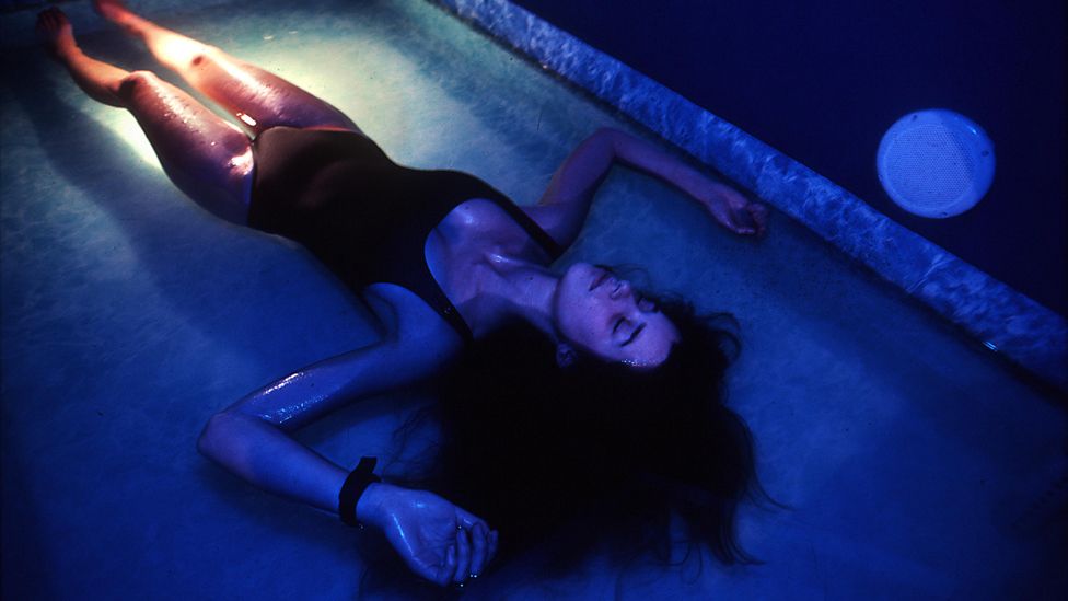 Woman lying down in flotation tank
