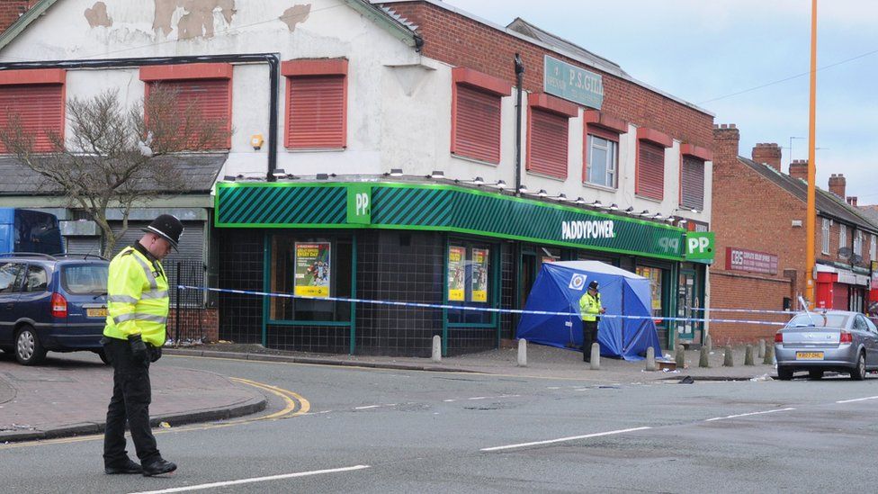 Police officers outside the Paddy Power shop