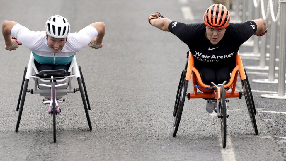 Two women wheelchair racers go hell for leather down the finishing stretch