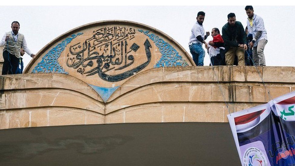 Iraqi students hang a banner off the main entrance of Mosul's University in January 2017