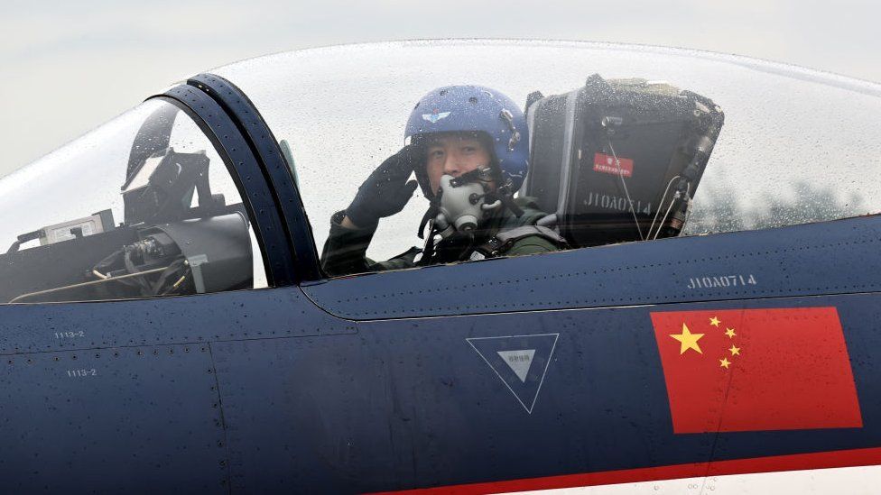 A pilot in a J-10 fighter jet of the People's Liberation Army Air Force salutes during the Changchun Air Show at Changchun Dafangshen Airport on 29 August 2022 in Changchun, Jilin, China