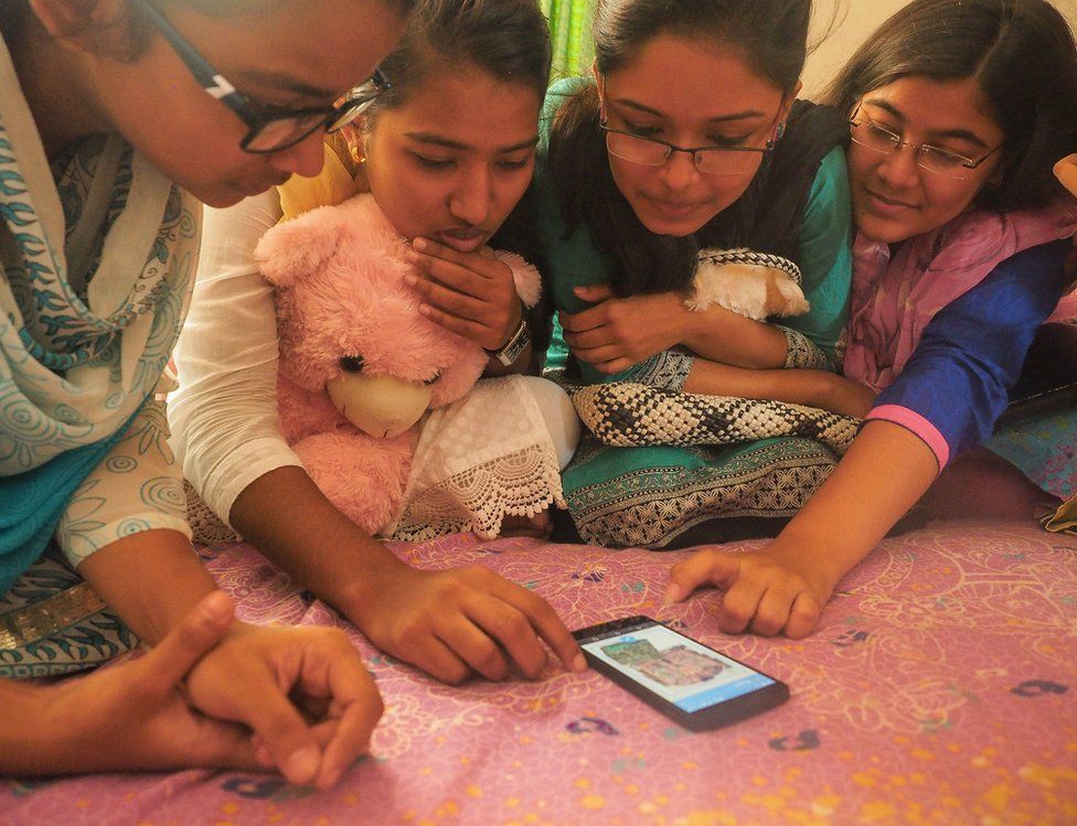 Bangladesh, 2015. Women gather around a smart phone.
