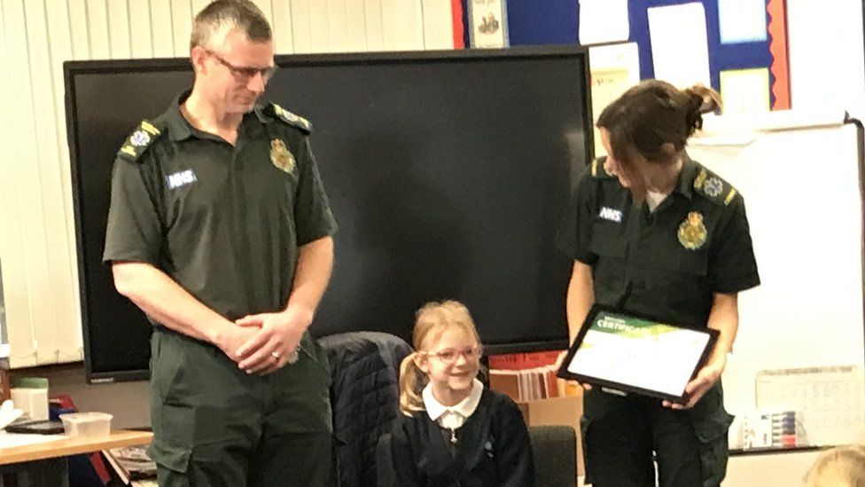 Daisy receives her bravery award from East Midlands Ambulance Service at a ceremony at school