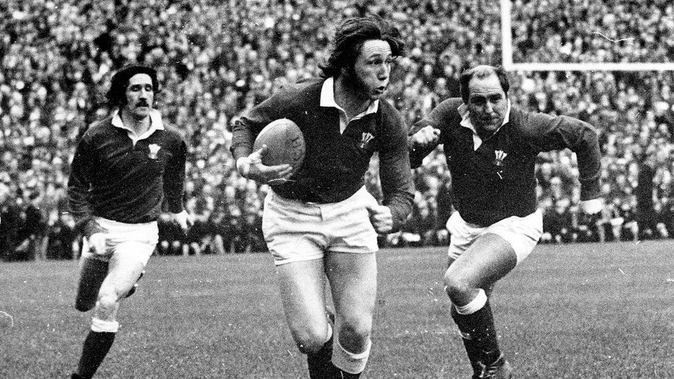 Welsh rugby legend JPR Williams running with the ball in his hand