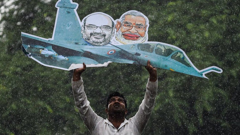 A supporter of the Indian Youth Congress holds a model of a Rafale fighter jet as he gets detained by Indian police during a protest in New Delhi on September 22, 2018.