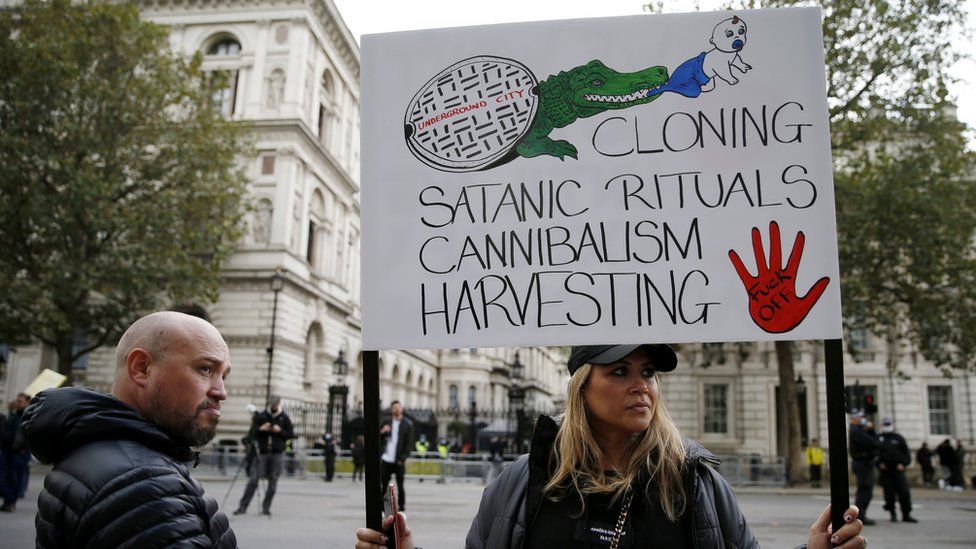 A protestor holds a sign during a "Save our Children" rally outside Downing Street on October 10, 2020 in London,