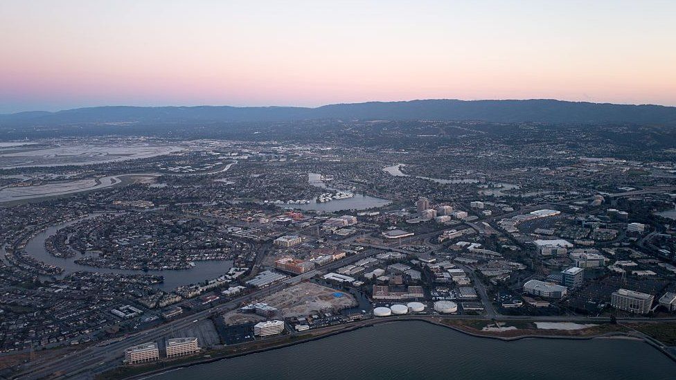Вид с воздуха на Силиконовую долину в сумерках, видна часть моста Сан-Матео/Хейворд, а также Фостер-Сити, включая штаб-квартиру Gilead Sciences, Visa и Conversica в Калифорнии, Калифорния, июль 2016 г.