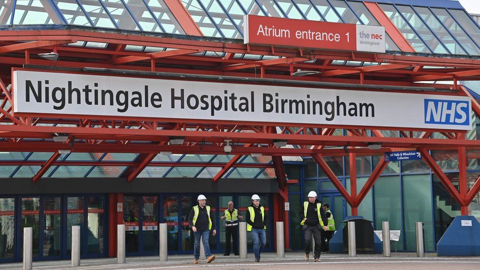A photo shows three construction workers leave the Nightingale Hospital Birmingham