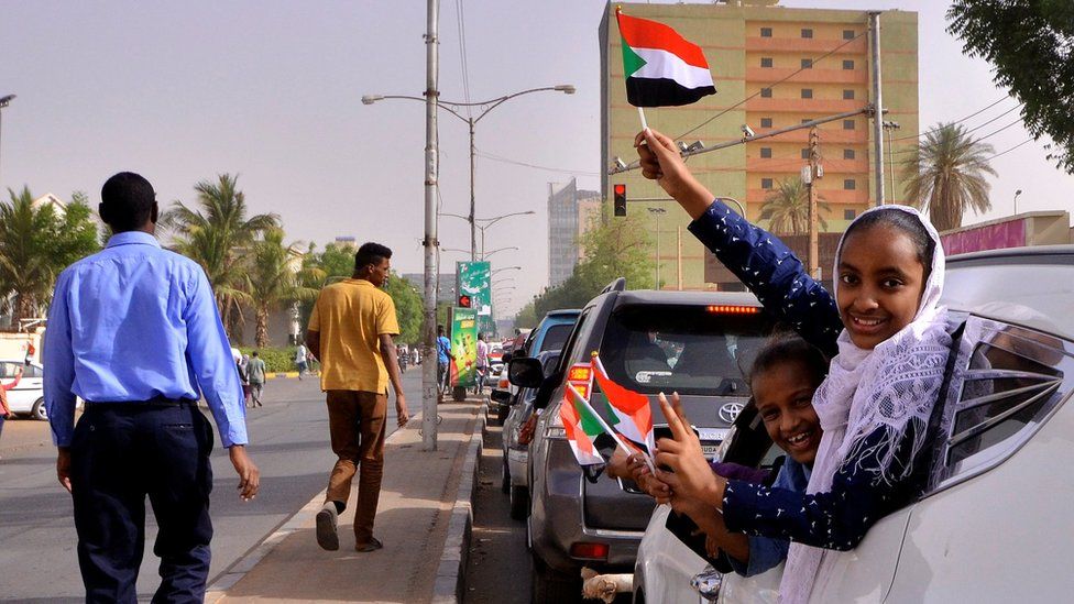 Demonstrators wave flags after Sudan's defence minister said that President Omar al-Bashir had been detained in Khartoum, Sudan April 11, 2019