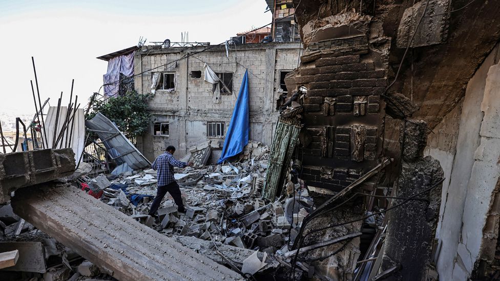 A man walks amid the rubble of a building destroyed during an Israeli army operation in the Jenin refugee camp in Jenin, on December 15, 2023