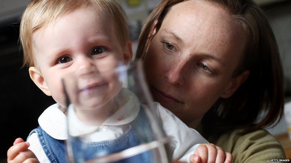 A mum gives her toddler filtered water
