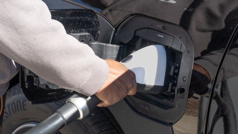 A man charging an electric car