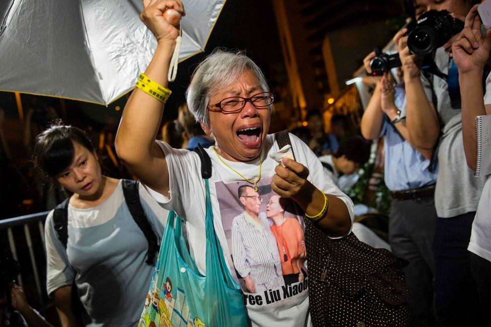 A protester reacts after paying her respects outside the Chinese Liaison Office of Hong Kong after the death of Chinese Noble laureate Liu Xiaobo, in Hong Kong on 13 July 2017