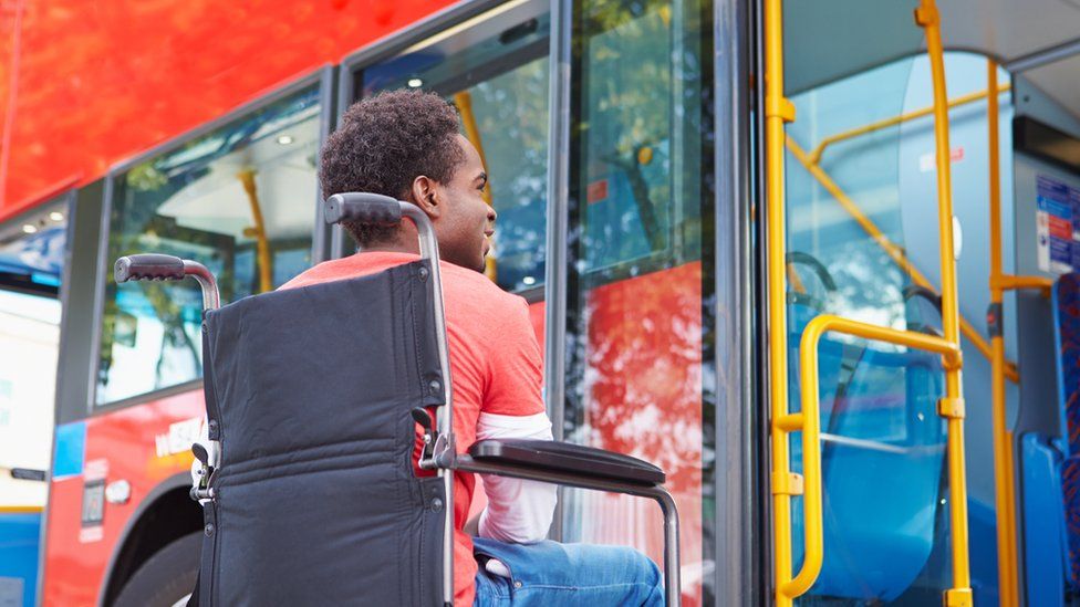 Man in wheelchair waiting by bus