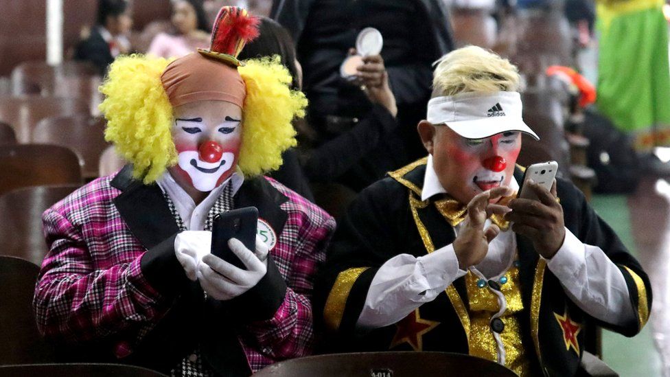 Clowns use their mobile phones during Peru's Clown Day celebrations in Lima, Peru May 25, 2018