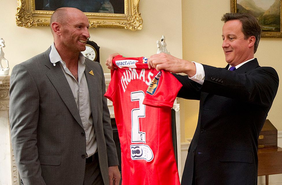 Presenting a shirt to then Prime Minister David Cameron in 2011 at a meeting of sports figures to discuss homophobia and transphobia in sport