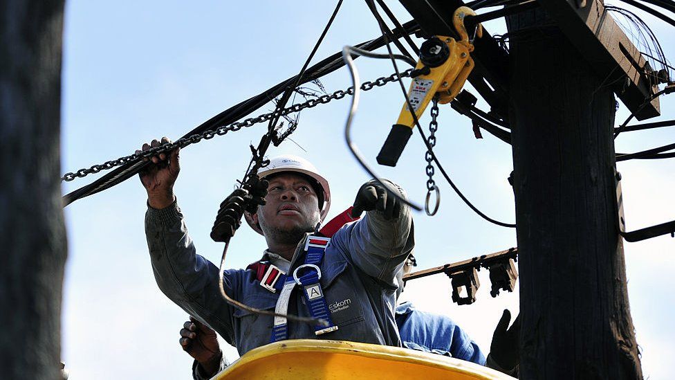 25 августа 2013 года рабочий отключает незаконные соединения от опоры электросети в Соуэто, Южная Африка.