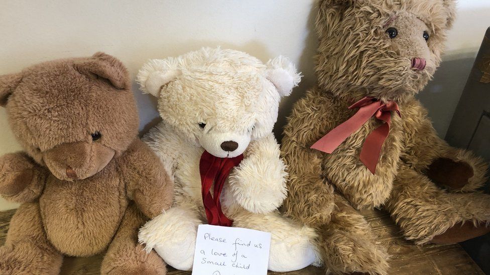Teddies with a sign saying "please find us a love of a small child"