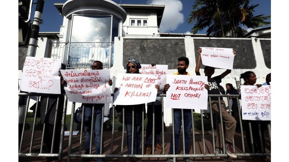 Protesters holding placards condemning the return of capital punishment outside the Welikada prison on Friday 28 June