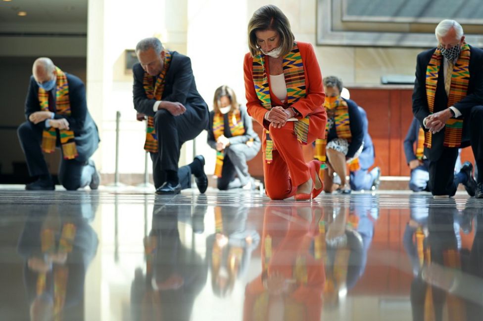 US Democrats kneel on a reflective floor