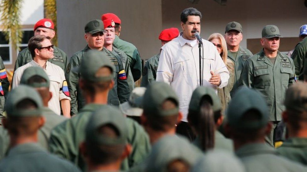 Handout picture released by Miraflores Palace press office showing Venezuela's President Nicolas Maduro (C) delivering a speech next to Venezuelan Defence Minister Vladimir Padrino (2-L) during the march of loyalty with personnel of the Venezuelan Bolivarian National Armed Forces (FANB) in Carabobo state, Venezuela on May 21, 2019.
