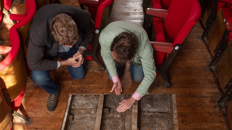 Dr Jonathan Clark and Tim FitzHigham looking at the original floorboards at St George's Guildhall in King's Lynn