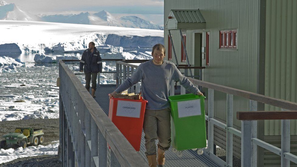 Man carrying waste recycle bins at Rothera research station
