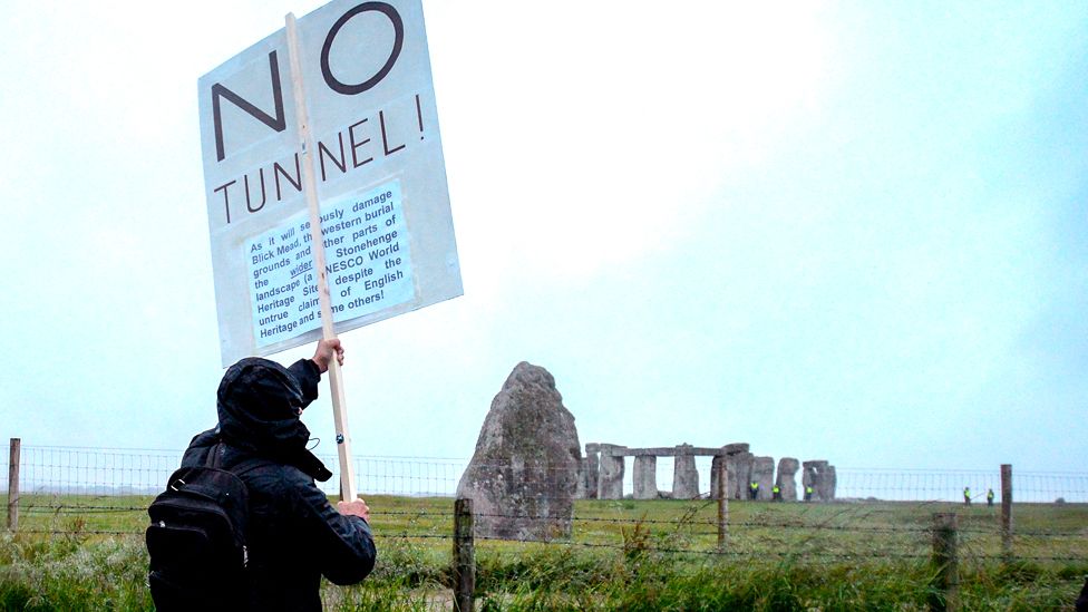 Man holds sign reading "No Tunnel"