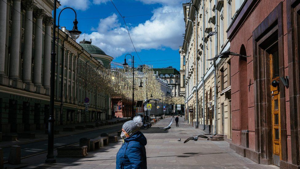 A woman walks down a deserted street in central Moscow on April 21, 2020