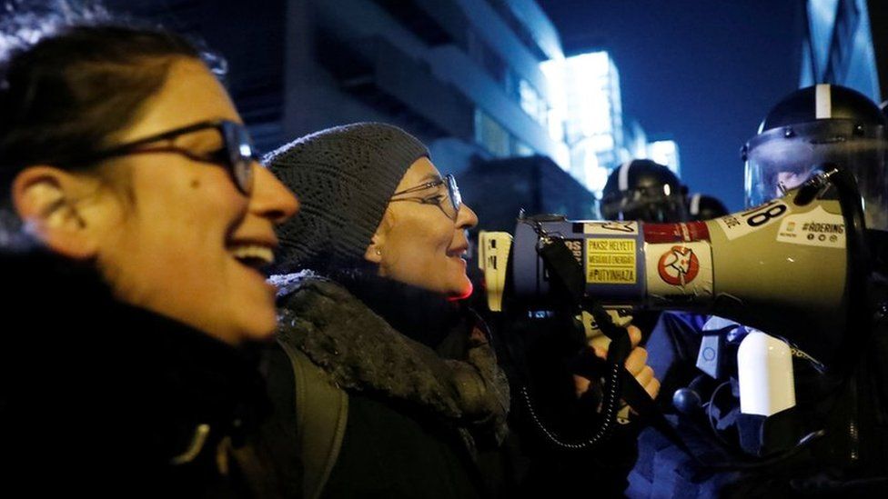 Protesters outside state TV denounced the new Overtime law as a "slave law" on Monday night