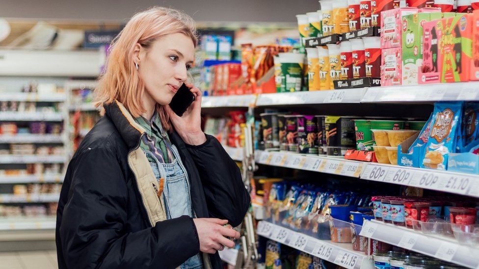 Woman in supermarket talking on mobile phone