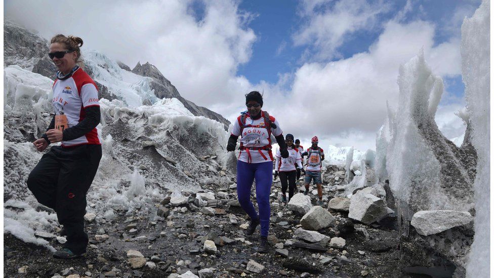 Runners, clad in warm clothing and hiking boots, run over rocky terrain, surrounded by ice, as they compete in the world's highest marathon, on 29 May. Photo released by organisers Himex.