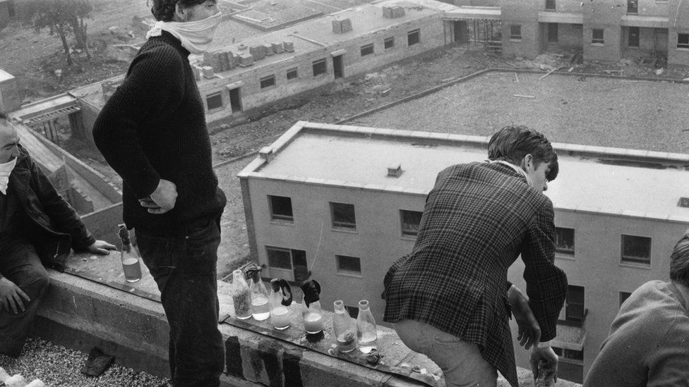 Young men on rooftops with unlit petrol bombs during the Battle of the Bogside