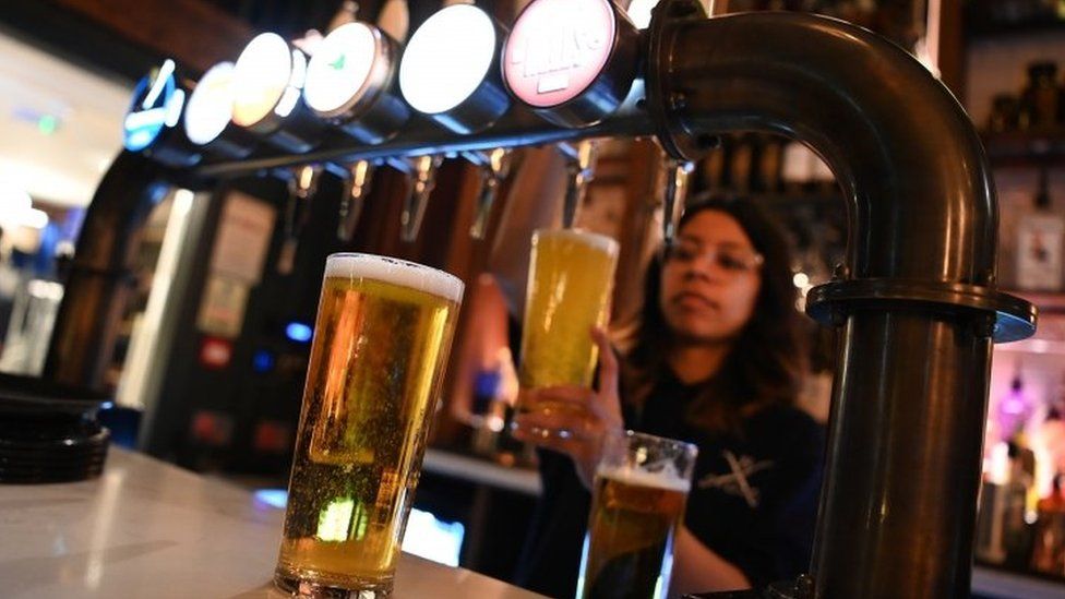 A pint being poured in a bar
