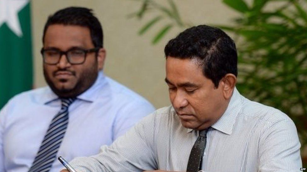 Maldivian President Abdulla Yameen (right) ratifies a land agreement as Vice President Ahmed Adeeb looks on (23 July 2015)