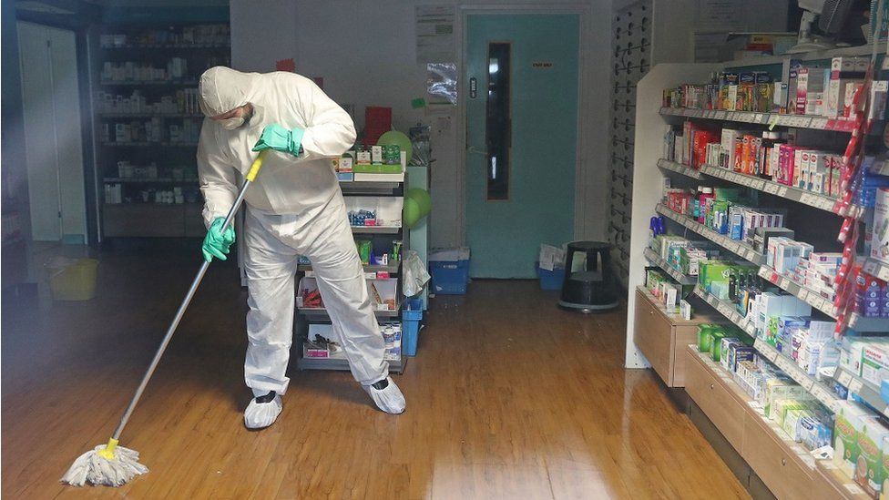 A man in protective clothing cleaning the County Oak Medical Centre
