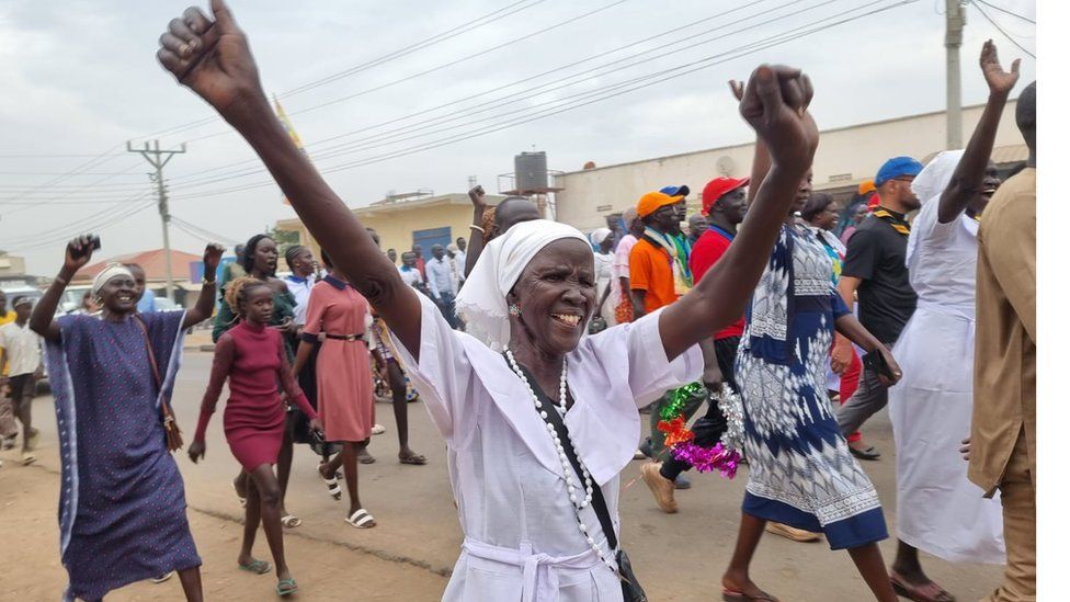 A pilgrim celebrates arriving in Juba