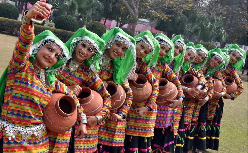 Indian student members of a folk dance group take a selfie photograph with a mobile phone at Punjabi University in Patiala on February 11, 2016.