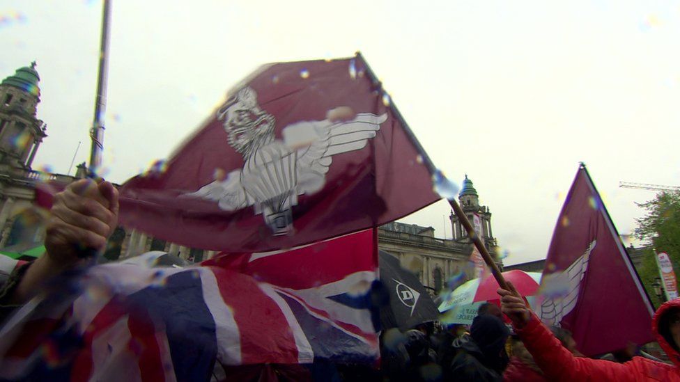 A Union flag and the flag of the parachute regiment are flown at the rally at Belfast City Hall