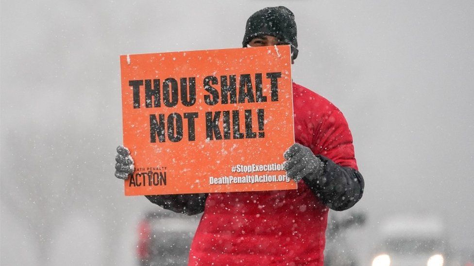 An activist in opposition to the death penalty protests during a snowstorm outside of the United States Penitentiary in Terre Haute, Indiana