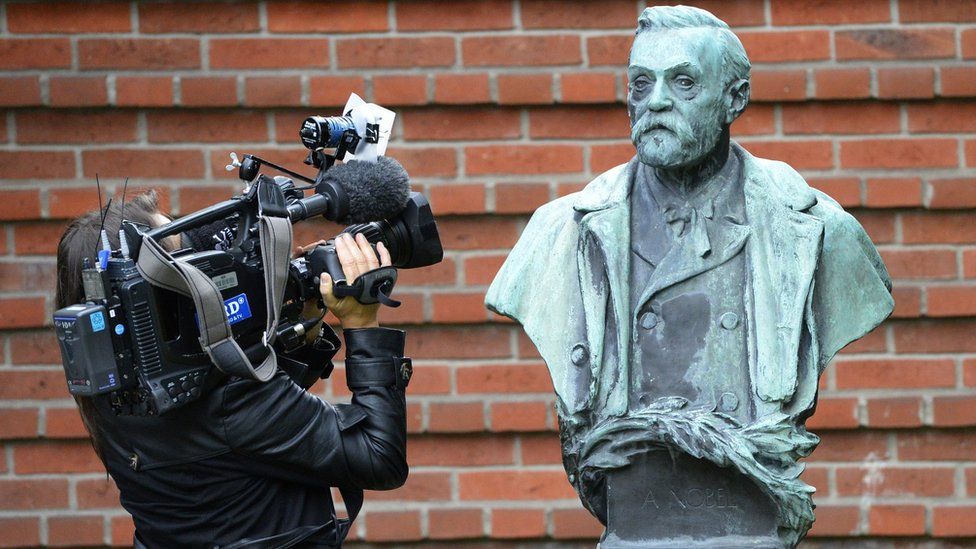 A woman films a statue of Swedish inventor of dynamite Alfred Nobel
