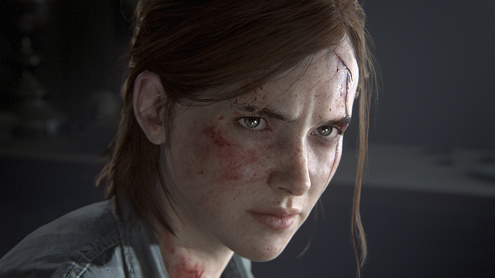 A young woman with hair tied back, but strands of loose hair suggesting she's recently exerted herself or been involved in a struggle. She's bleeding from a small gash on her forehead and is spattered with spots of blood. She's staring intensely at someone just out of shot.