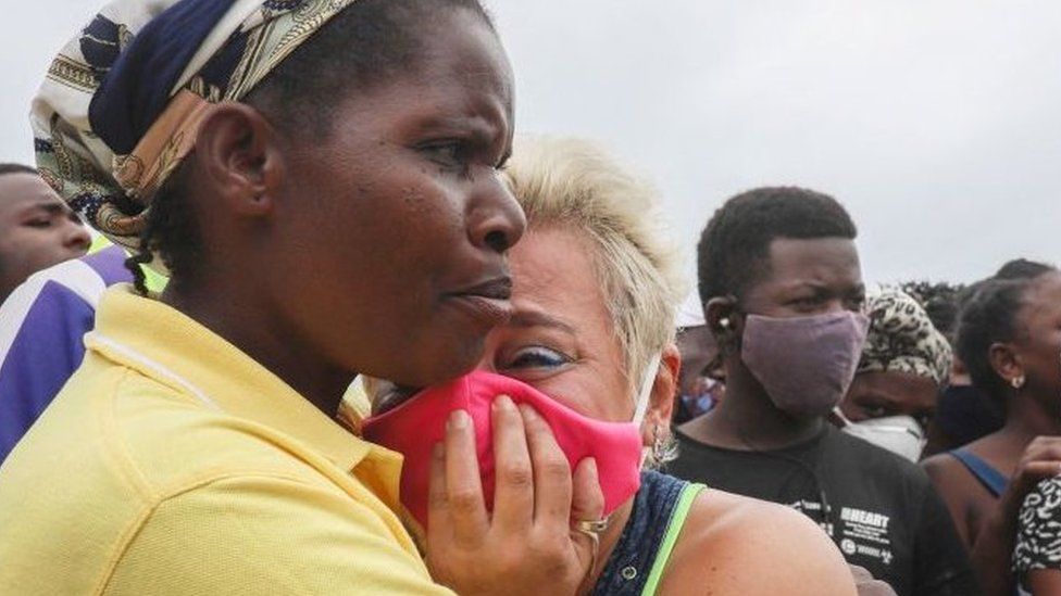 Женщина плачет, ожидая прибытия сына на Пембу 1 апреля 2021 года с лодки эвакуированных с побережья Пальмы.