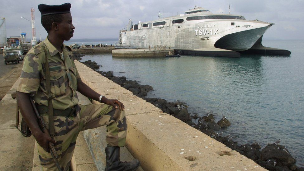 A Djiboutian soldier stands guard near a US transporter ship