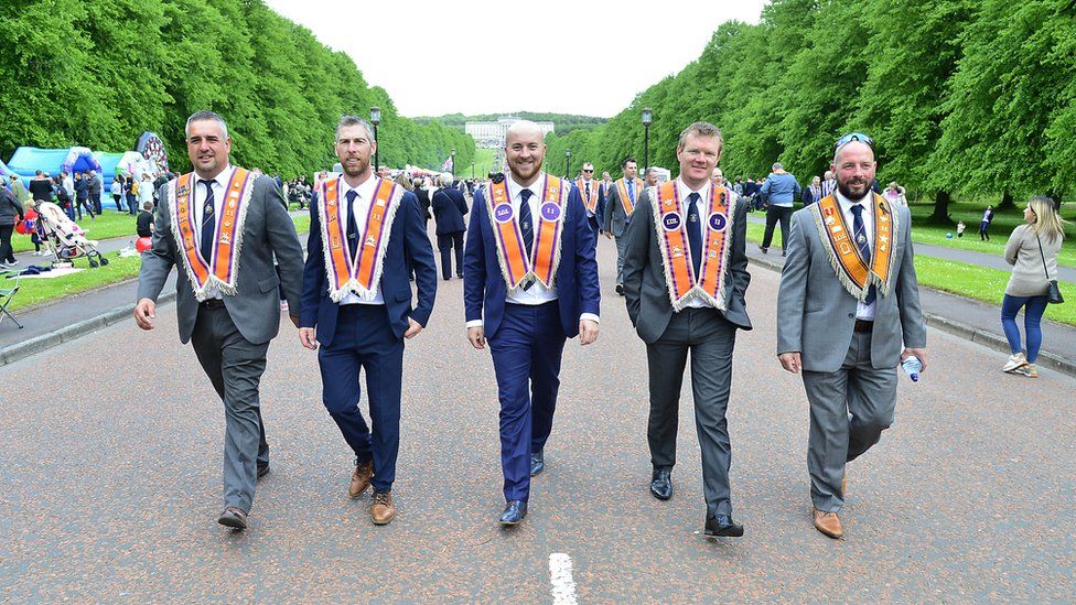 Five Orange Order members walk down Stormont mile