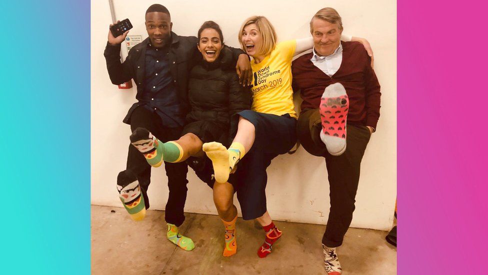 Doctor Who cast in their colourful socks.